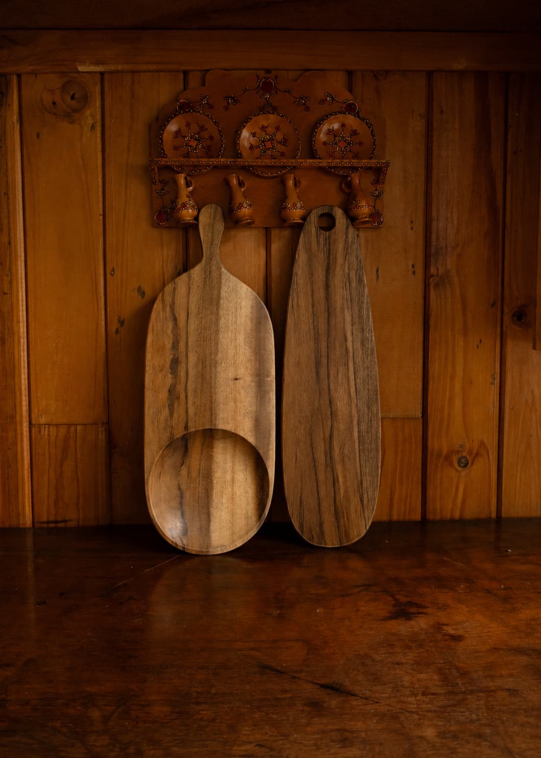 Tabla de madera pequeña y tabla de madera mediana apoyadas sobre mueble de madera.