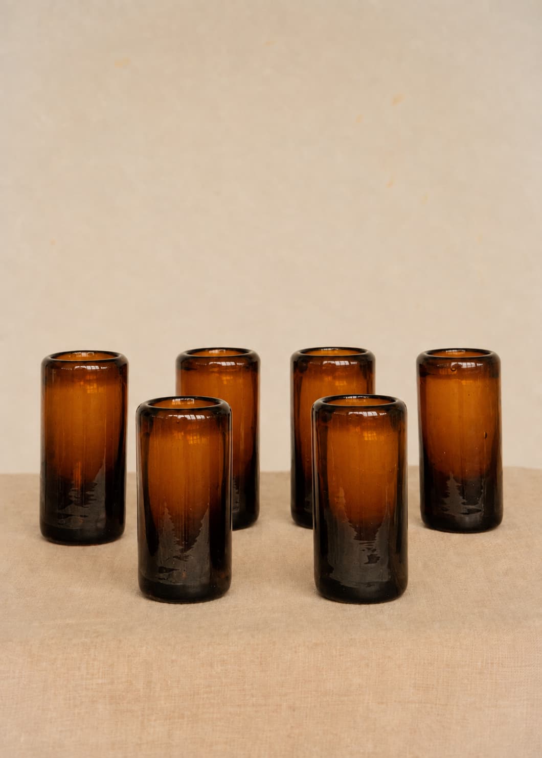 Set de seis vasos de shot artesanales en vidrio ámbar reciclado, vista frontal.