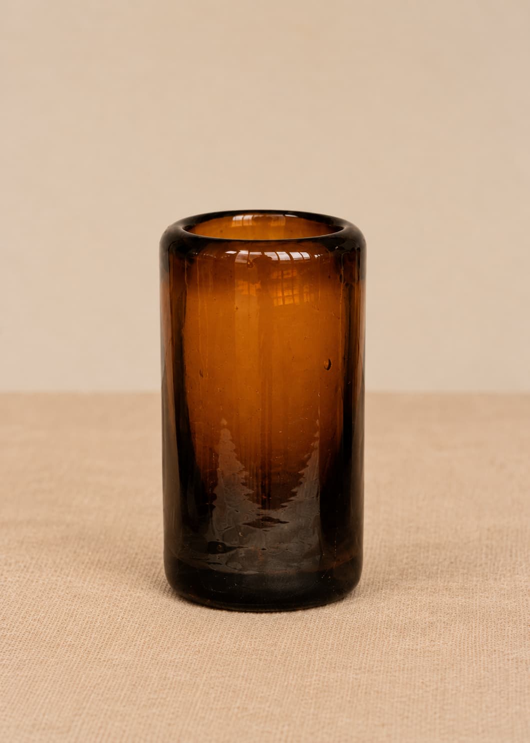 Vaso de shot artesanal en vidrio ámbar reciclado, vista individual.