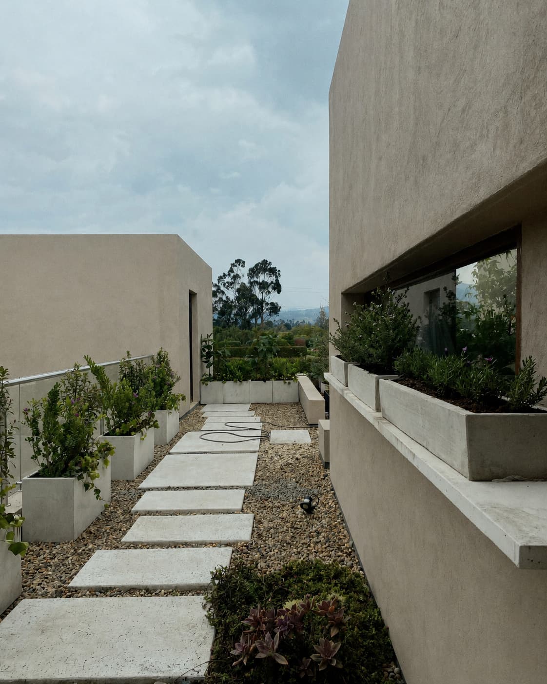 Antes del mantenimiento en terraza de Casa Tagua, con materas rectangulares, cubos y camino de piedra en Reserva de Potosí.