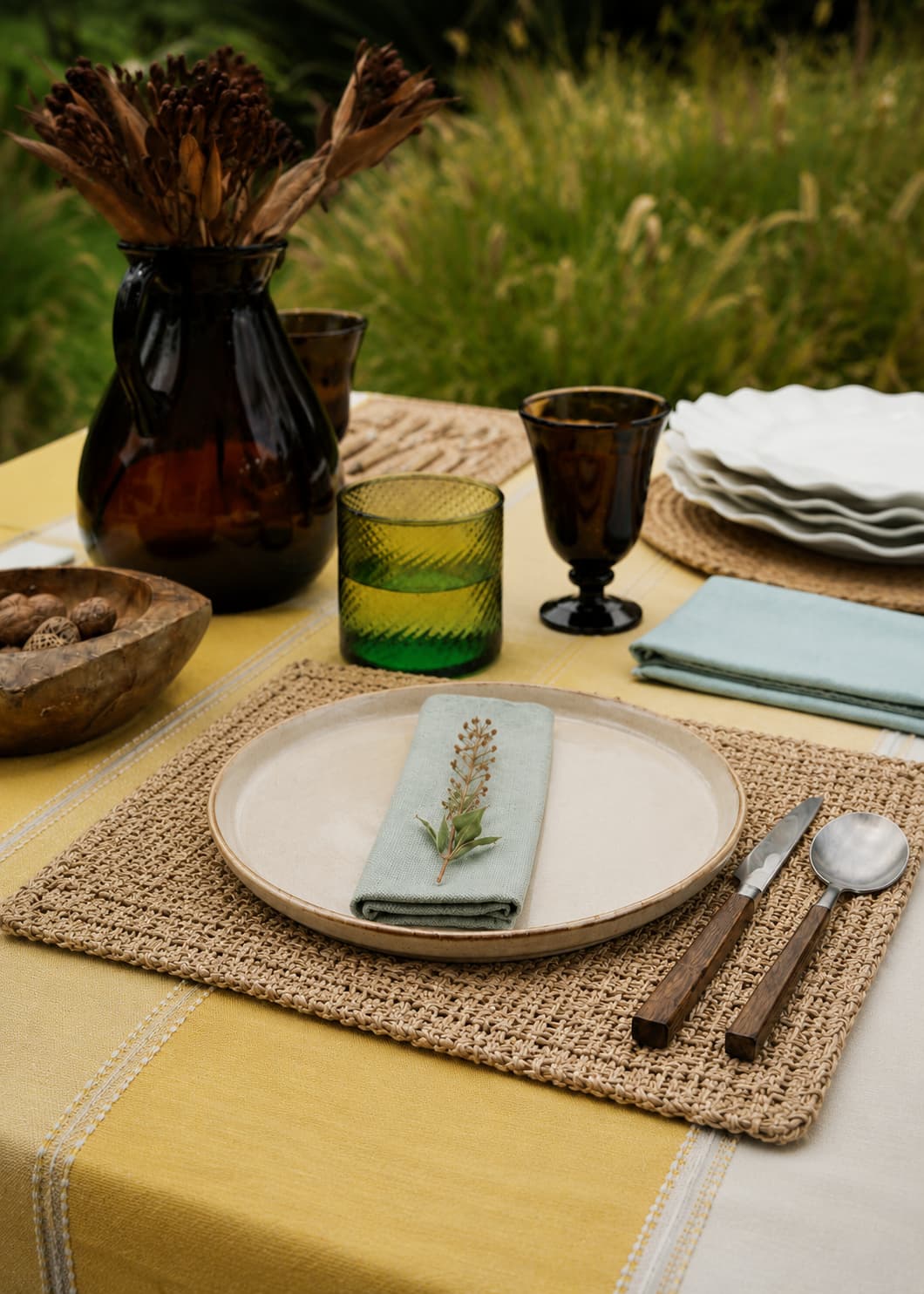Individual rectangular de fique natural en mesa puesta con vajilla, servilleta de lino y cubiertos.