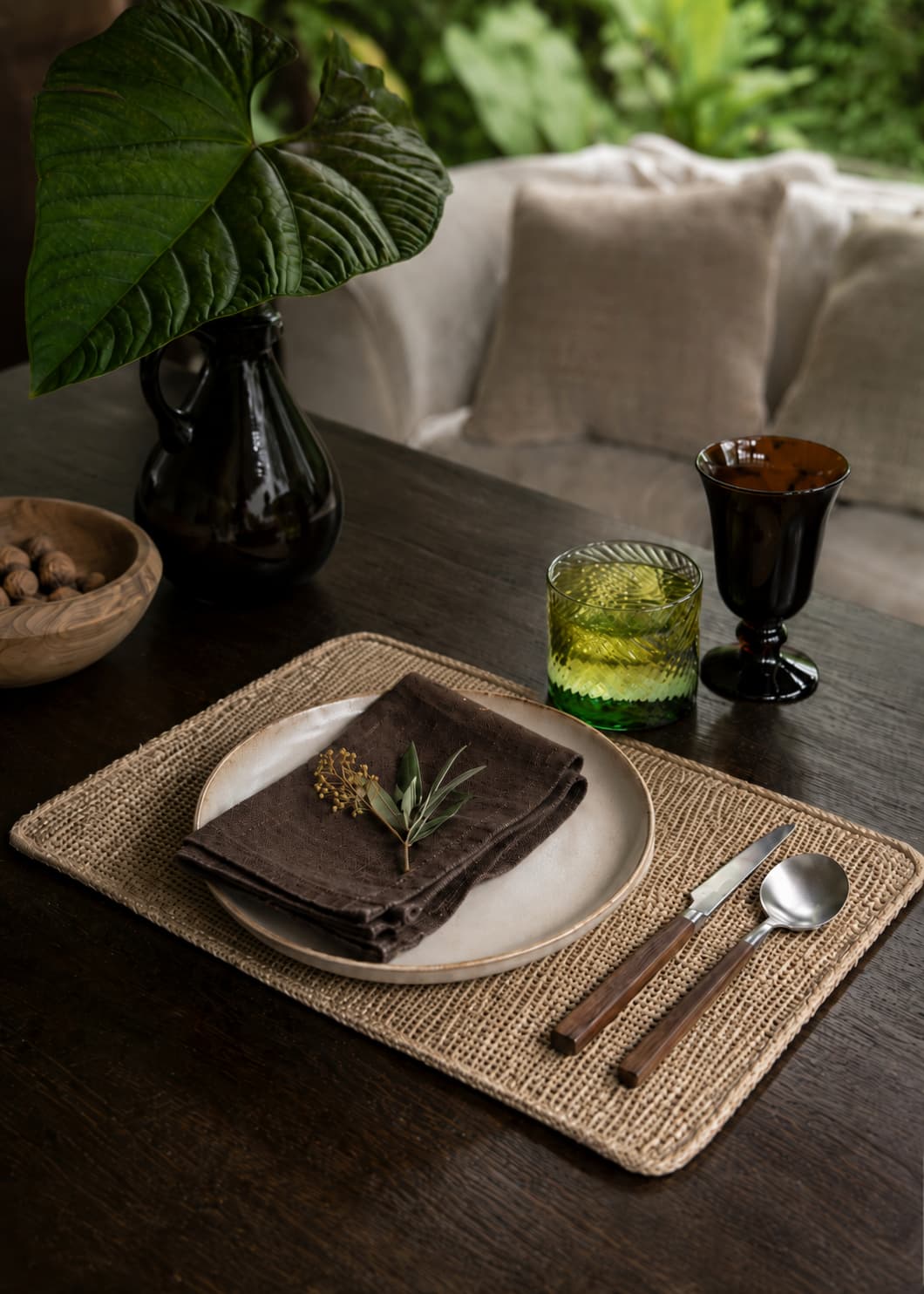 Individual rectangular natural en mesa puesta con vajilla, servilleta de lino y cubiertos.