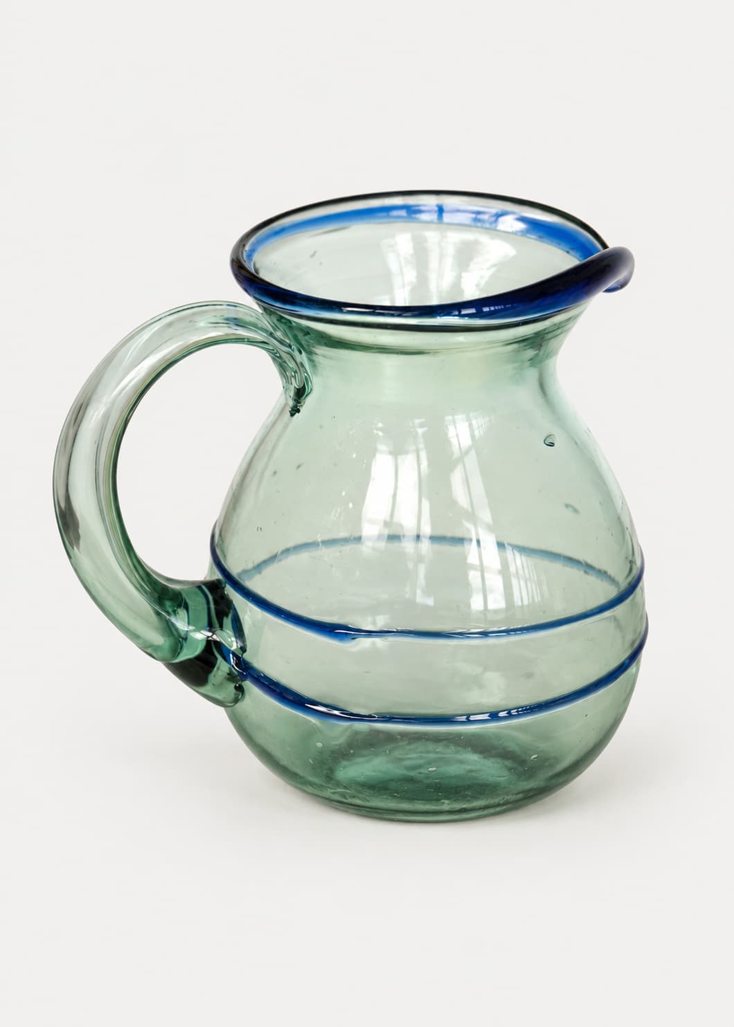 Jarra Dos Hilos Azul de vidrio soplado reciclado sobre fondo gris claro.