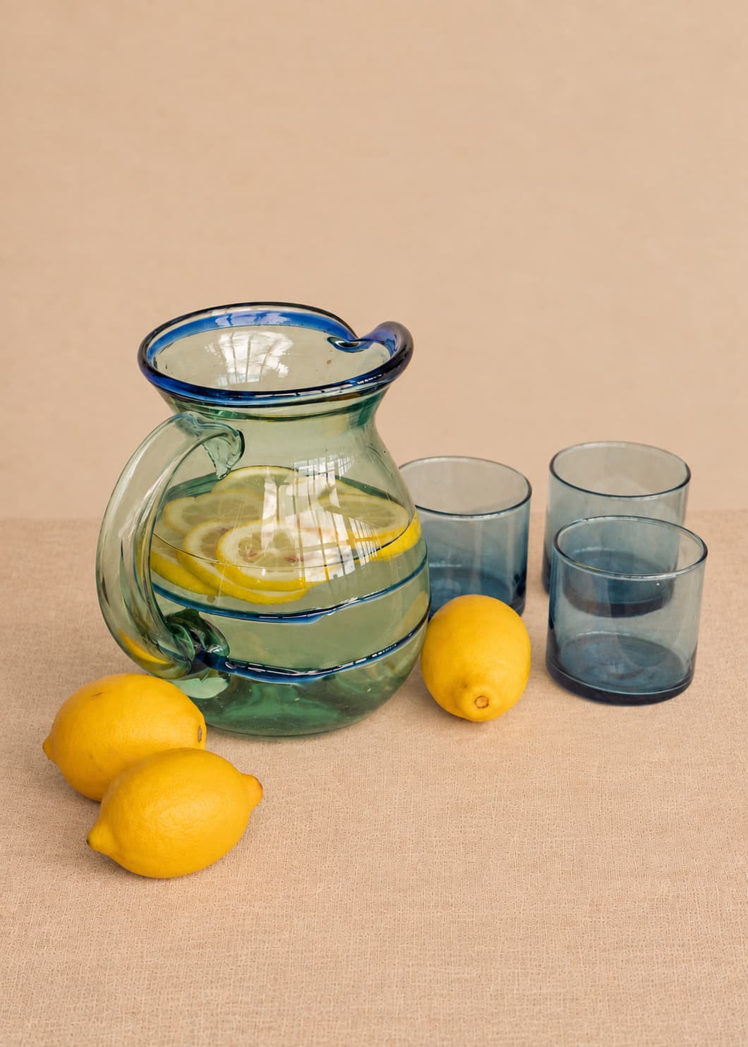 Jarra Dos Hilos en vidrio soplado acompañada de vasos y limones.