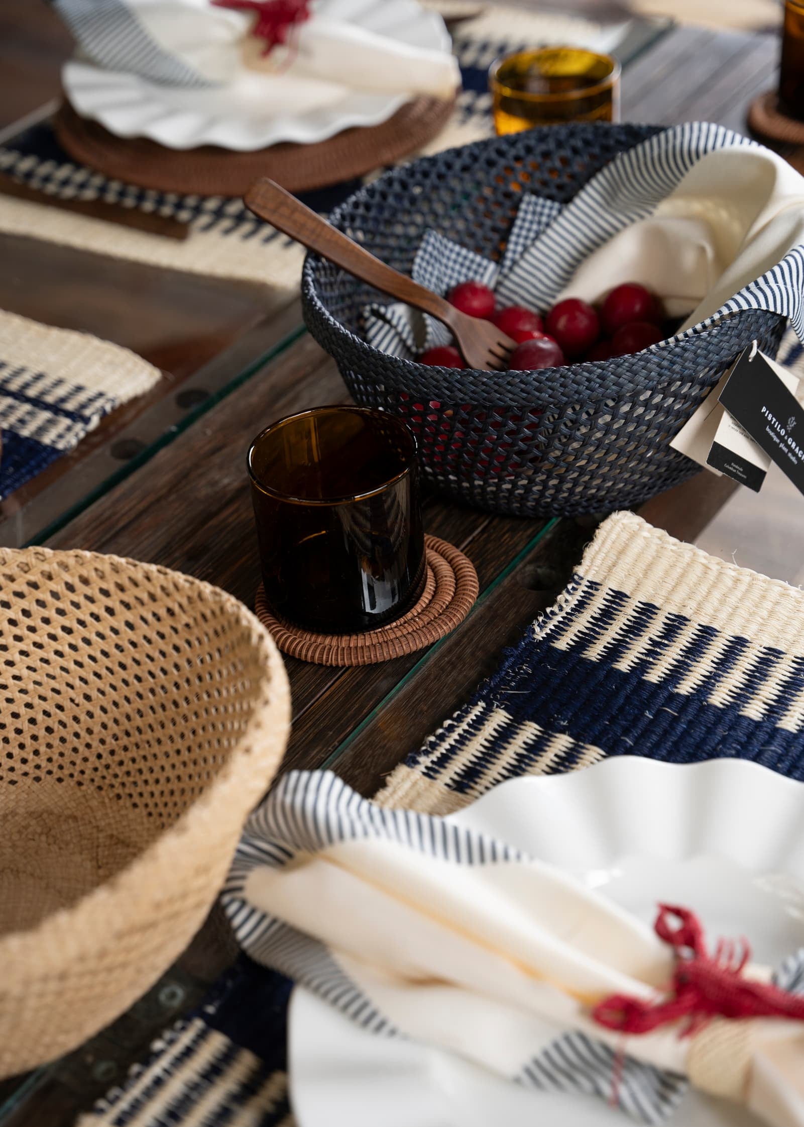 Vaso corto ámbar en mesa puesta con textiles y piezas artesanales de fibras naturales 
